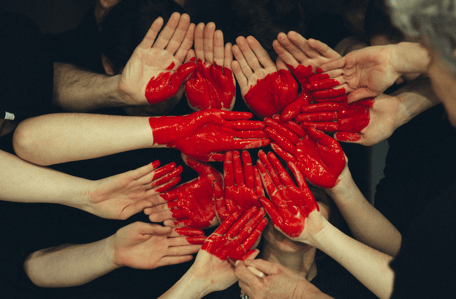red heart painted on hands